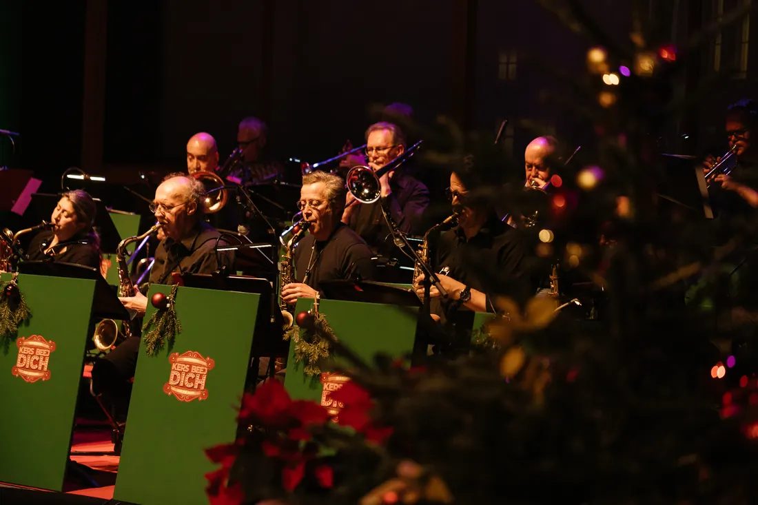 De blazerssectie van de KBD Big Band achter groene lessenaars