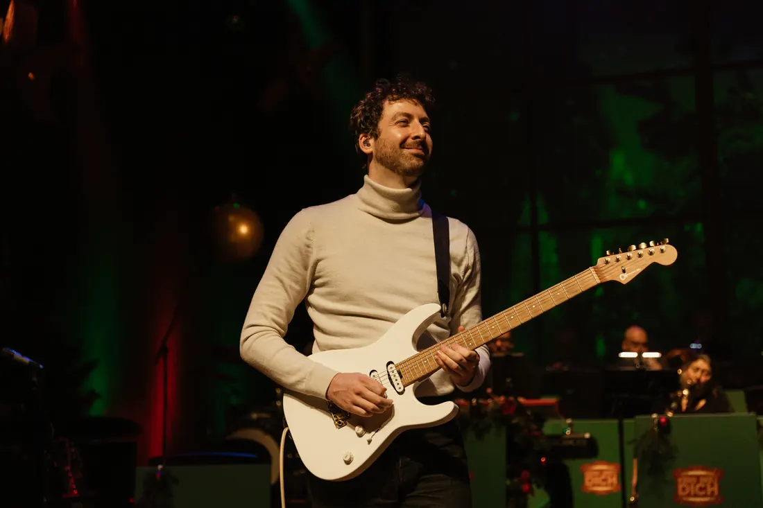 Gitarist van de KBD Big Band in een witte coltrui