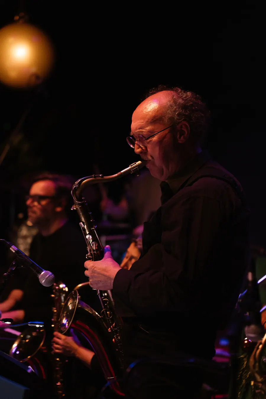 Saxofonist in warm rood licht