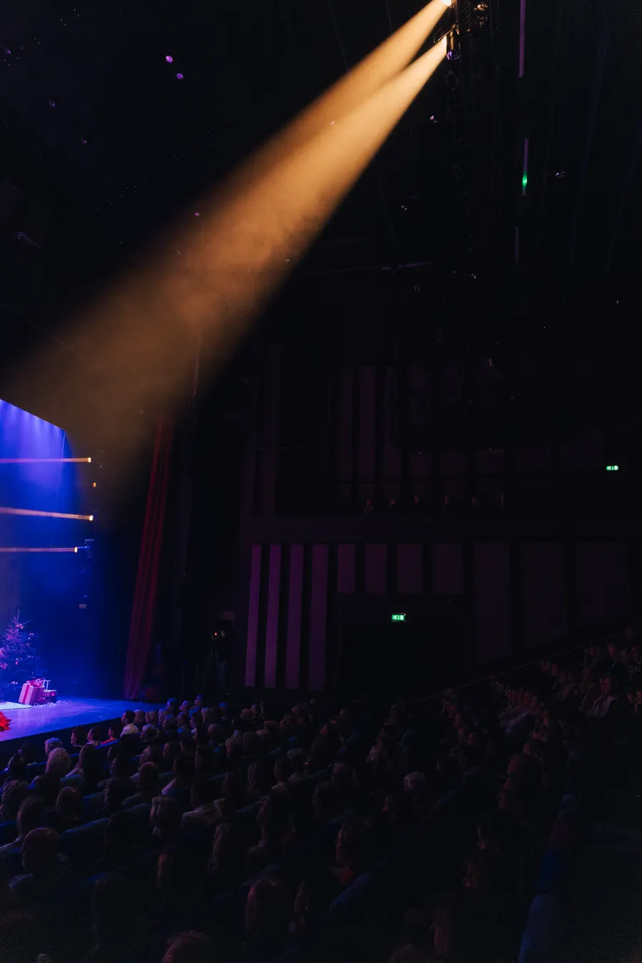 Een spotlight schijnt over de volle zaal